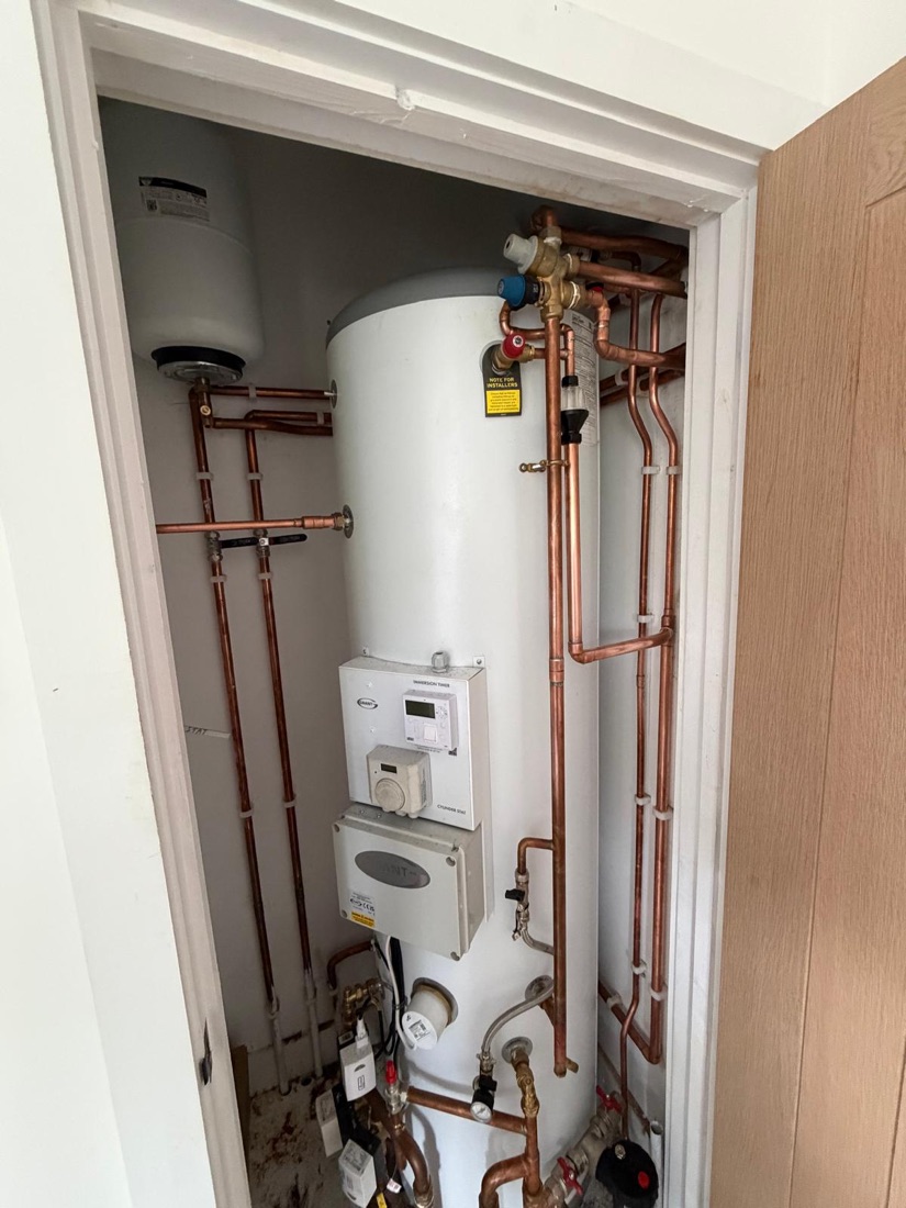 Unvented hot water cylinder installed in an airing cupboard