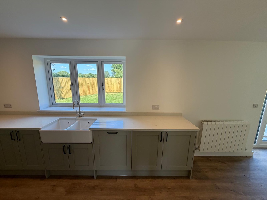 Kitchen plumbing with double Belfast sink under the window