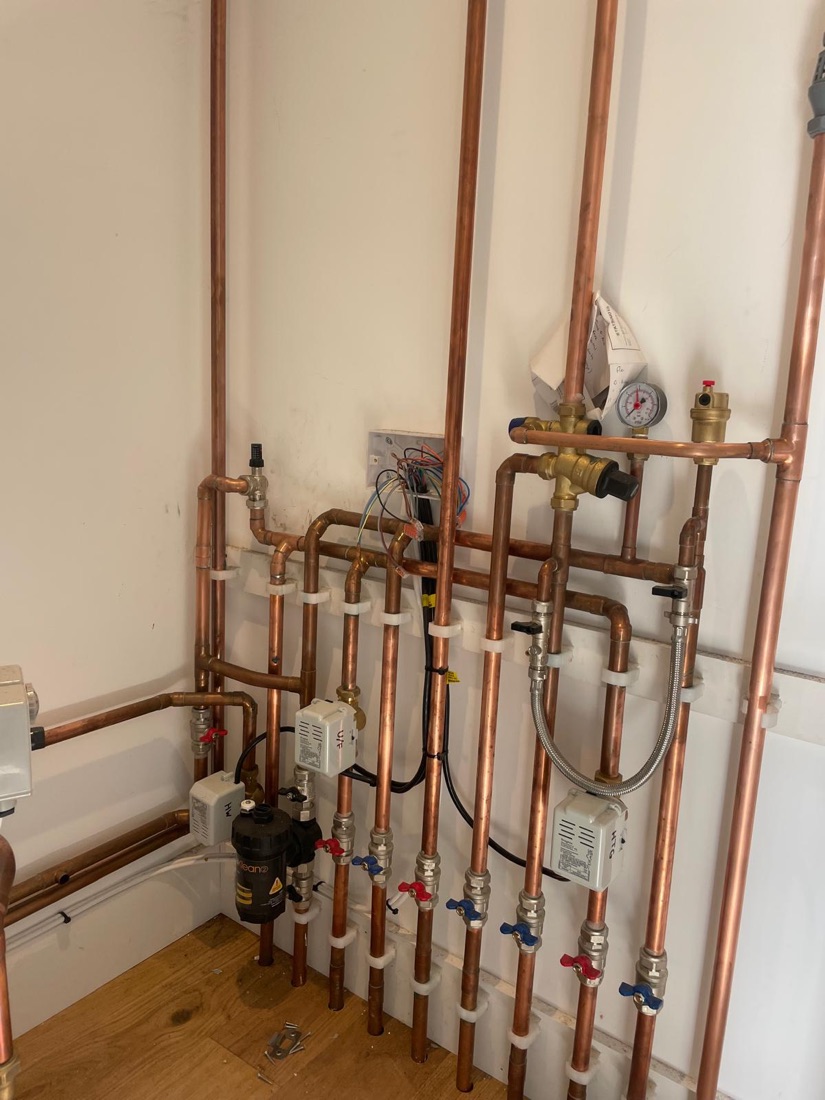 New central heating pipework — neatly clipped copper manifold with zone valves