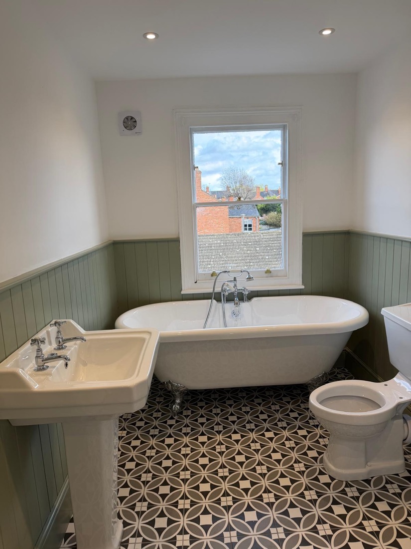 Traditional bathroom with roll-top bath, period floor tiles and panelled walls